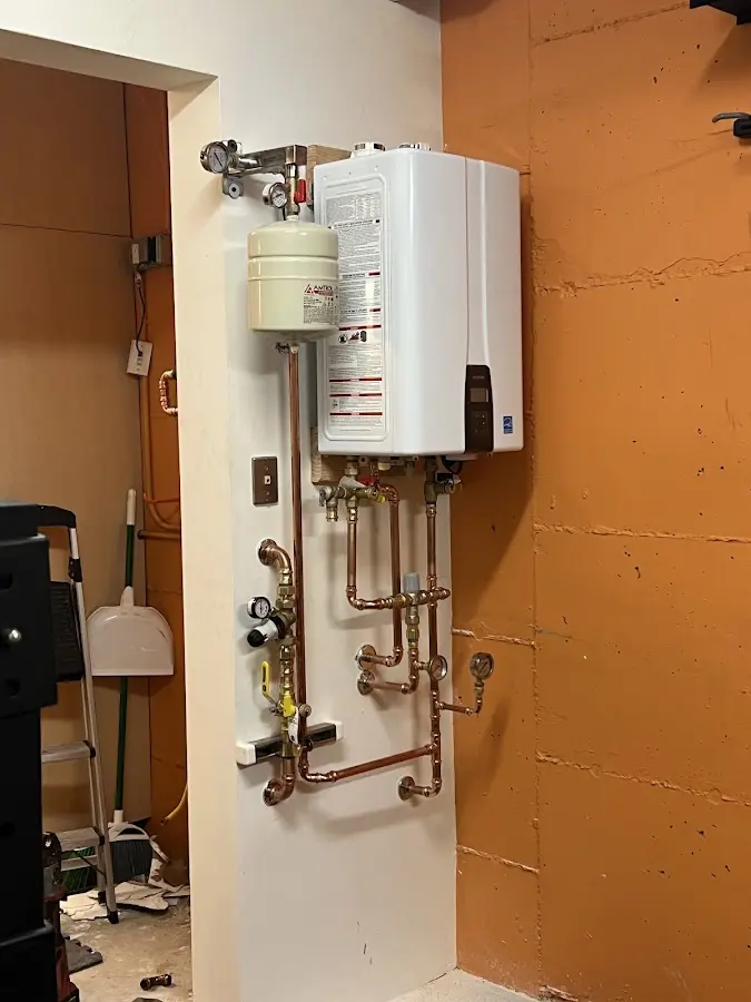 Plumbing technician inspecting water heater connections in Mount Plymouth